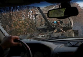 Ukrajinski vojnici voze tenk, gledano kroz vjetrobransko staklo automobila